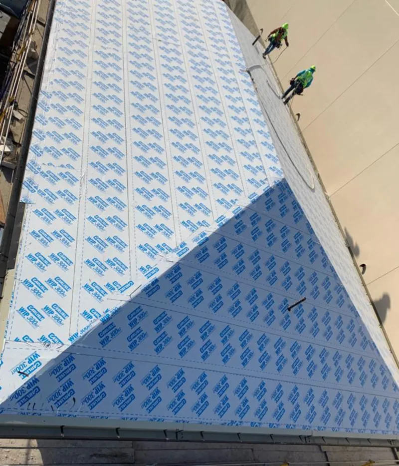 Professional roofers installing underlayment on a metal roof in Port Jefferson